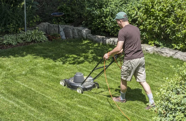 Man maaien gazon met een elektrische grasmaaier — Stockfoto