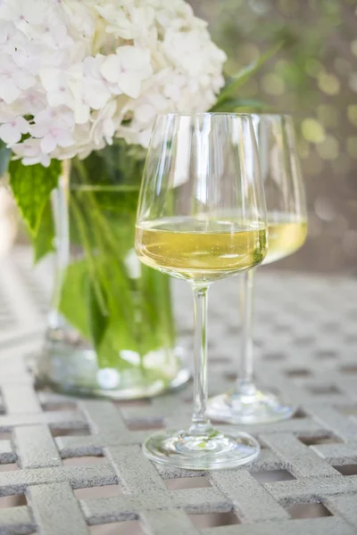 Deux verres de vin blanc sur une table de jardin — Photo