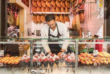 Madrid, İspanya - 7 Ekim 2017: Iberico jambon yemek ahır piyasada satan adam