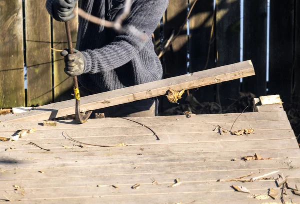 Man Ontmantelen Van Een Oud Houten Dek Met Een Crowbar — Stockfoto