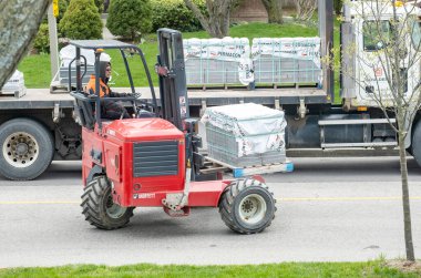 Toronto, Kanada - 28 Nisan 2020: Banliyö Caddesi 'ndeki Beton Taş Yığını Taşımak İçin Kırmızı Forklift kullanan İşçi