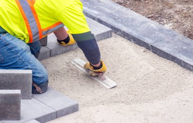Güvenlik Ceketi Giyen İşçi Veranda Pavers Vakfı Kumu Şövalyelerle Yumuşatarak Hazırlıyor