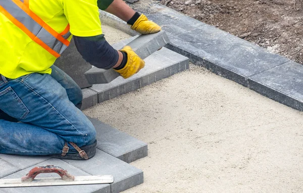 Dělník Bezpečnostní Vestě Pokládání Patio Pavers Dvorku — Stock fotografie