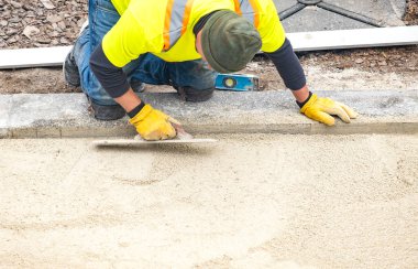 Toronto, Kanada - 29 Nisan 2020: Patio Pavers Vakfı 'nı Trowels ile Yumuşatarak Hazırlayan Güvenlik Ceketli İşçi