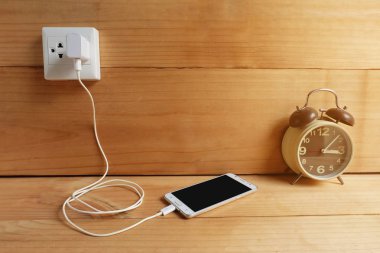 Adaptör güç kablosu şarj ahşap zemin üzerinde cep telefonu takın