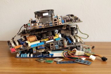 Anakart yığını, elektronik ekipman, basılı devre kartı ve ahşap zemindeki hasar, elektronik atık problemleri, çevre kirliliği.