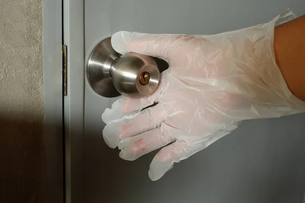 Wear Plastic gloves to touch and open the public toilet doors to prevent infection During coronavirus covid-19 outbreak, Concept of pandemic virus.