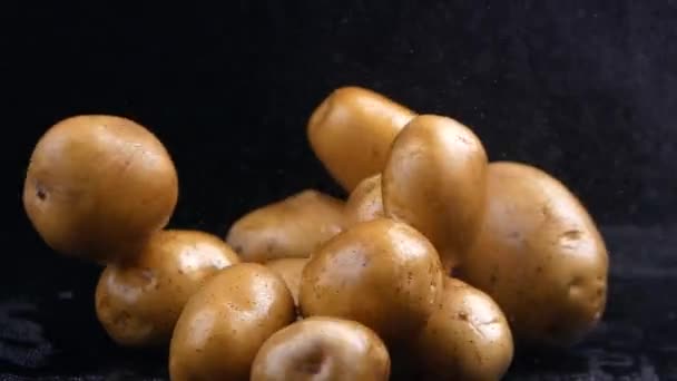 在黑背景音乐录影带中分离的生土豆 — 图库视频影像