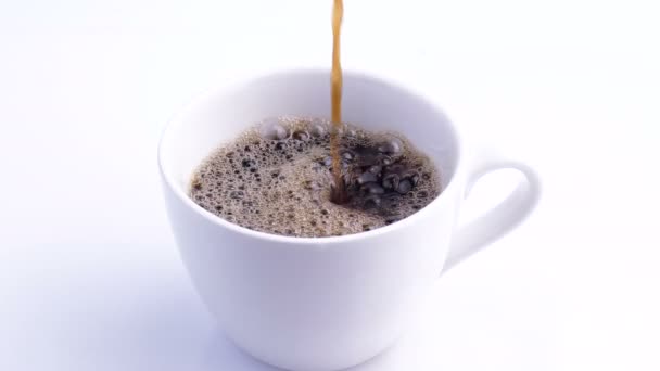 A white cup of coffee on the table. Slow Motion coffee pour. — ストック動画