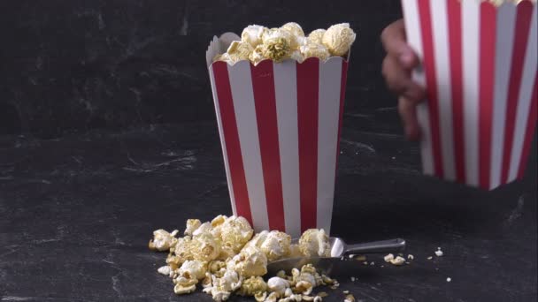 Zwei rote Schalen voller Popcorn auf schwarzem Hintergrund — Stockvideo