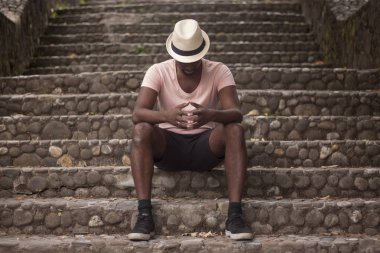 Bir sakallı dostum / Hint siyahi bir beyaz şapka ve yaz giyim, eski bir şehir sokaklarında aşağı bakıyor / kavram düşünme bir turist olarak portresi