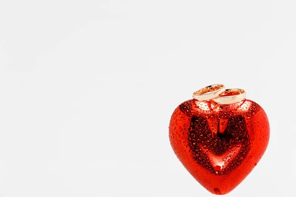 Два Золотых Обручальных Кольца Красном Сердце Капельками Воды Сердце Изолированный — стоковое фото