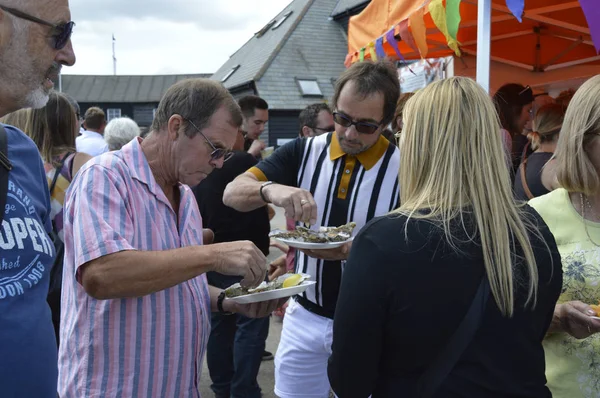 WHITSTABLE, UK-JULY 22: Los visitantes disfrutan de un plato de ostras alrededor del puerto, como parte del festival anual Whitstable Oyster Festival. 22 de julio de 2017 en Whitstable kent Reino Unido . — Foto de Stock