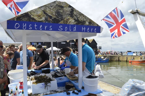 WHITSTABLE, UK-JULY 22:Fishmongers prepare and shuck oysters for the thousands of visitors who flock to  the annual Whitstable Oyster Festival. July 22, 2017 in Whitstable kent UK. — Stock Photo, Image
