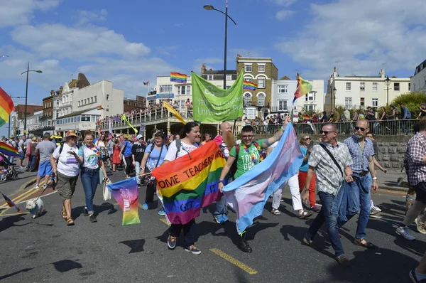 MARGATE, UK-ELOKUU 12: Väkijoukot katsovat ihmisiä, jotka kantavat lippuja ja bannereita marssimassa värikkäässä Gay Pride Paradessa, joka on osa vuosittaista Margate Pride festivaalia. Elokuu 12, 2017 kaupungissa: Margate, UK . — kuvapankkivalokuva