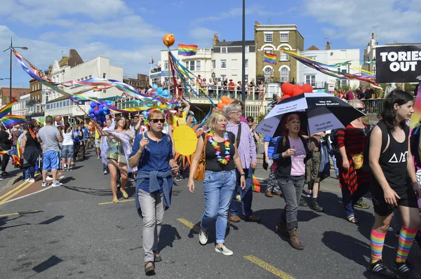 MARGATE, UK-AUGUST 12: Crowds watch people carrying flags and banners marching in the colourful Gay Pride Parade, part of the annual Margate Pride festival. August 12, 2017 in Margate, UK. — Stock Photo, Image