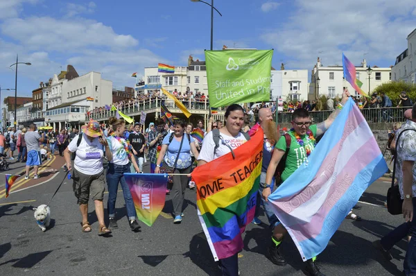 MARGATE, UK-AUGUST 12: Crowds watch people carrying flags and banners marching in the colourful Gay Pride Parade, part of the annual Margate Pride festival. August 12, 2017 in Margate, UK. — Stock Photo, Image