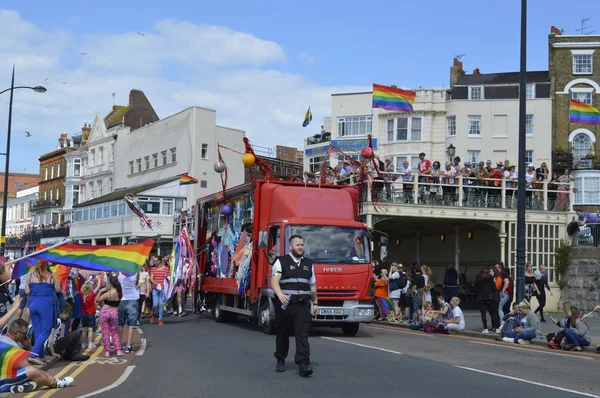 MARGATE, Reino Unido-AGOSTO 12: Um carro alegórico leva pessoas carregando bandeiras e bandeiras marchando no colorido Desfile do Orgulho Gay, parte do festival anual Margate Pride. 12 de agosto de 2017 em Margate, Reino Unido . — Fotografia de Stock