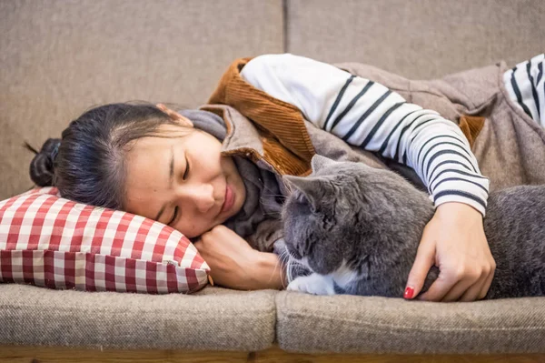 Ragazza e gatto dormire sul divano — Foto Stock