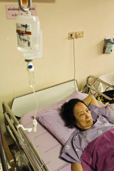 Old asian woman lying in hospital bed