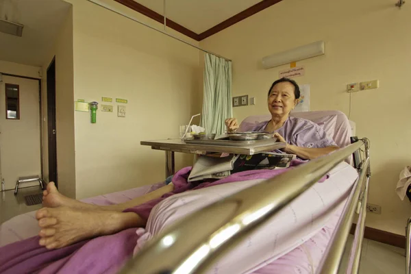 Gammal asiatisk kvinna i sjukhussängen Royaltyfria Stockfoton