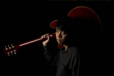 Asyalı genç müzisyen gitar çalmak