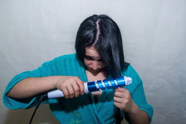 Wanita menyetrika rambutnya Stok Foto