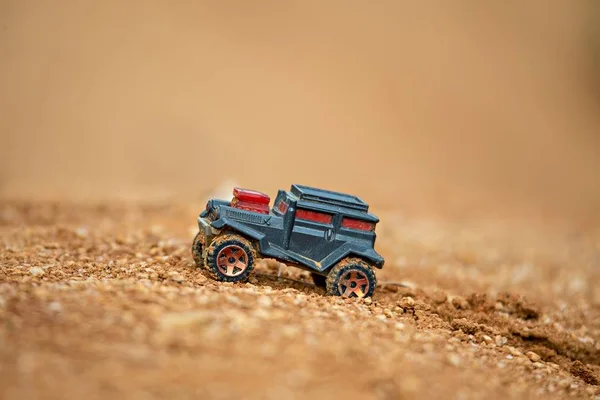 Leksaks bil offroading på lera med mjukt fokus och vackra bokeh — Stockfoto