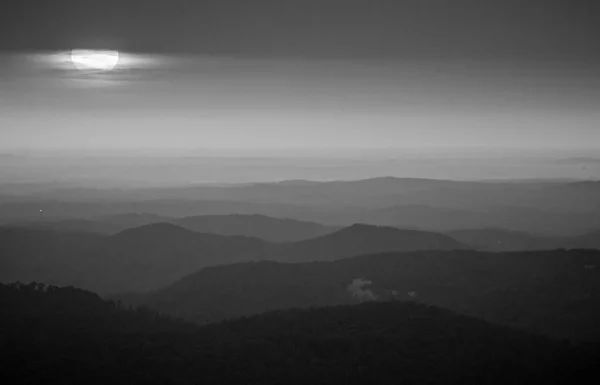 Sonnenaufgangssonne lugt durch die Wolken über dem Gebirge — Stockfoto