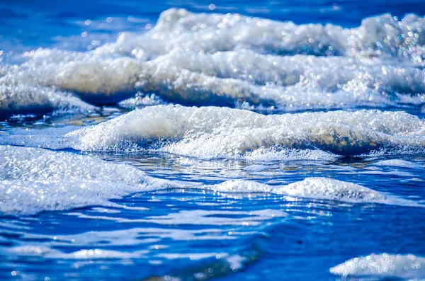 Zblízka pohled na krásné modré moře vlny s bílou pěnou — Stock fotografie
