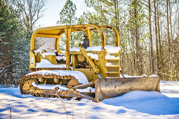 Bulldozer no local de construção coberto com neve — Fotografia de Stock