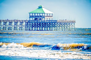 Folly beach balıkçılık iskele ve güneşli d üzerinde arazi içine çökmesini dalgalar