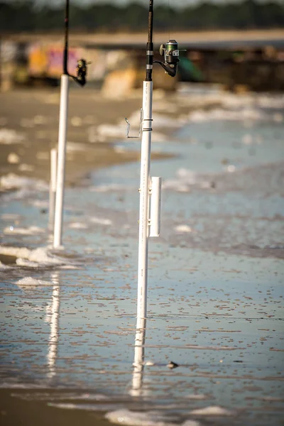 Fishing rods dug into ocean beach coast — Stock Photo, Image