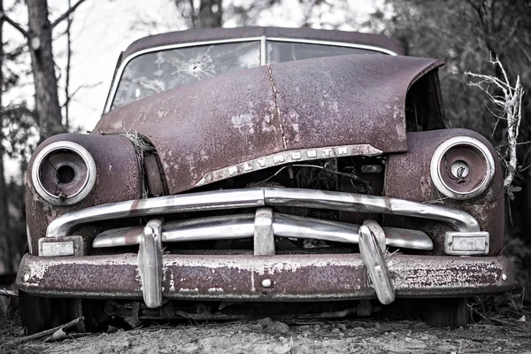 Vecchia auto arrugginita abbandonata nel bosco — Foto Stock