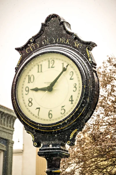 Relógio de rua histórico vintage com neve caindo no inverno — Fotografia de Stock