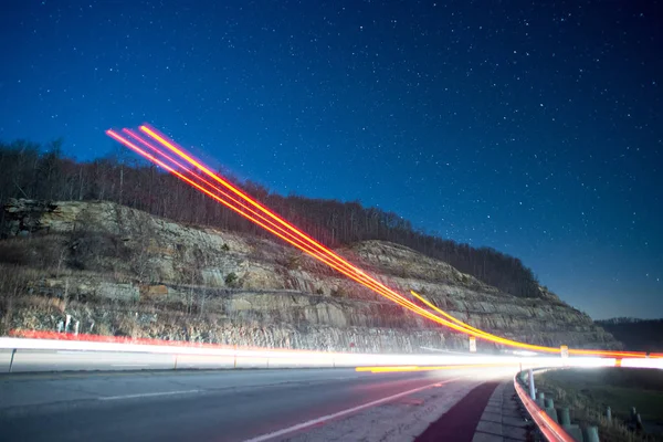 Senderos ligeros por la noche en las montañas del tráfico saliente —  Fotos de Stock