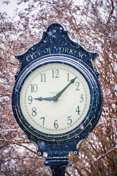 Vintage gamla gatan klocka med snö faller på vintern — Stockfoto