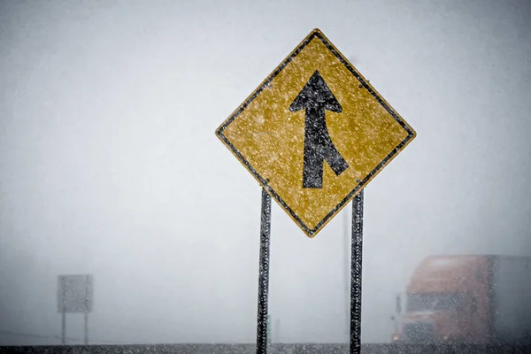 Merge sign barely seen through winter storm — Stock Photo, Image