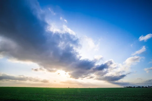 Весняні фермерські поля з заходом сонця і хмарами в текстах — стокове фото