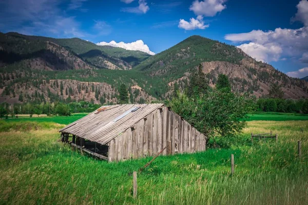 Atardecer de verano con un granero rojo en Montana rural y Rocky Mountai — Foto de Stock