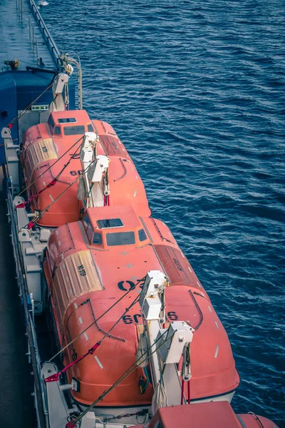 Barcos salva-vidas laranja anexados ao convés do navio de cruzeiro — Fotografia de Stock