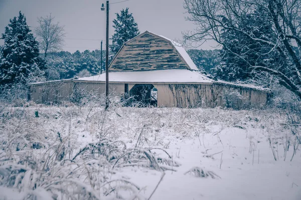 古い納屋の周りの地面に座っている新鮮な雪 — ストック写真