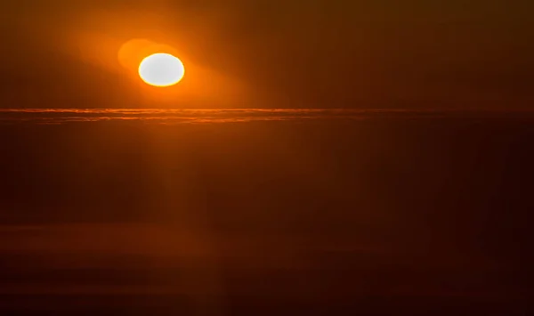 Pôr do sol ou nascer do sol de um avião espreitando pelas nuvens — Fotografia de Stock