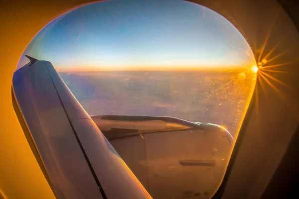 Nuvole e cielo visti attraverso la finestra di un aereo all'alba — Foto Stock