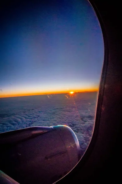 Chmury i niebo widziany przez okno samolotu o wschodzie słońca — Zdjęcie stockowe
