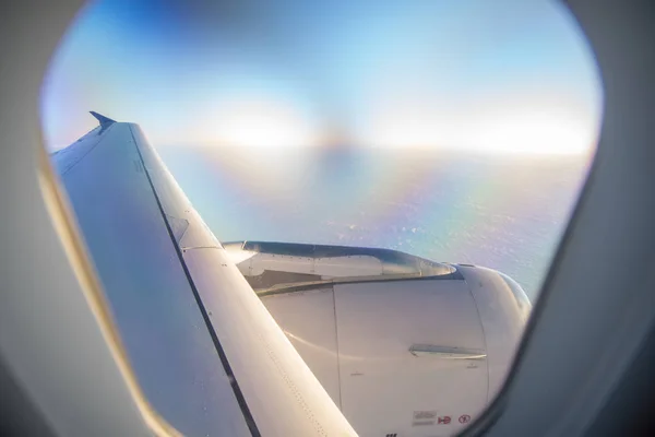 Nuages et ciel vus à travers la fenêtre d'un avion au lever du soleil — Photo