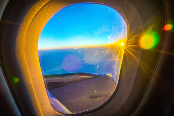 Wolken en hemel zoals gezien door raam van een vliegtuig bij zonsopgang — Stockfoto