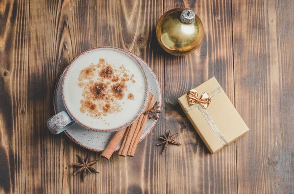 Eggnog. Traditional christmas cocktail, cinnamon sticks on a woo — Stock Photo, Image