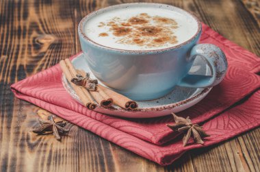 Eggnog. Tarçın çubuklu geleneksel Noel kokteyli ve kırmızı peçete ve ahşap masa anason..