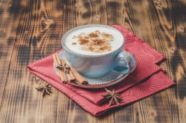 Eggnog. Tarçın çubuklu geleneksel Noel kokteyli ve kırmızı peçete ve ahşap masa anason..